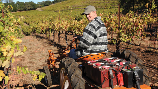 Jon-Mark Chappellet aboard his 1949 Allis Chalmers G model tractor, which he converted to electric