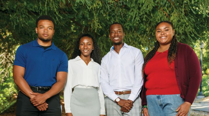 A group of four young people smiling at the camera